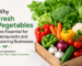 A wooden crate filled with fresh vegetables including broccoli, lettuce, carrots, bell peppers, cauliflower, tomatoes, onions, garlic, and cucumber, symbolizing the importance of fresh produce for restaurants and catering businesses.